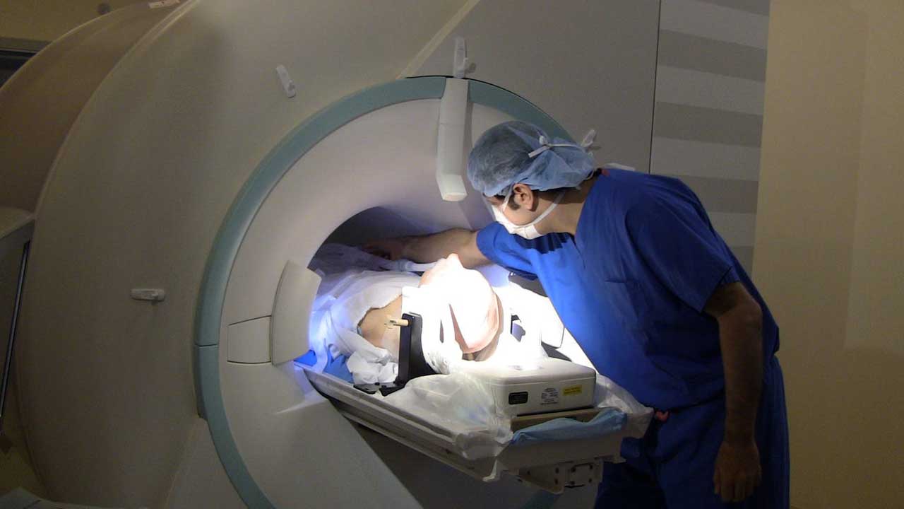 Dr. Azmi and MRI machine scanning Parkinson's patient