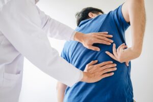 Doctor helping patient with Back Pain for Pain Relief