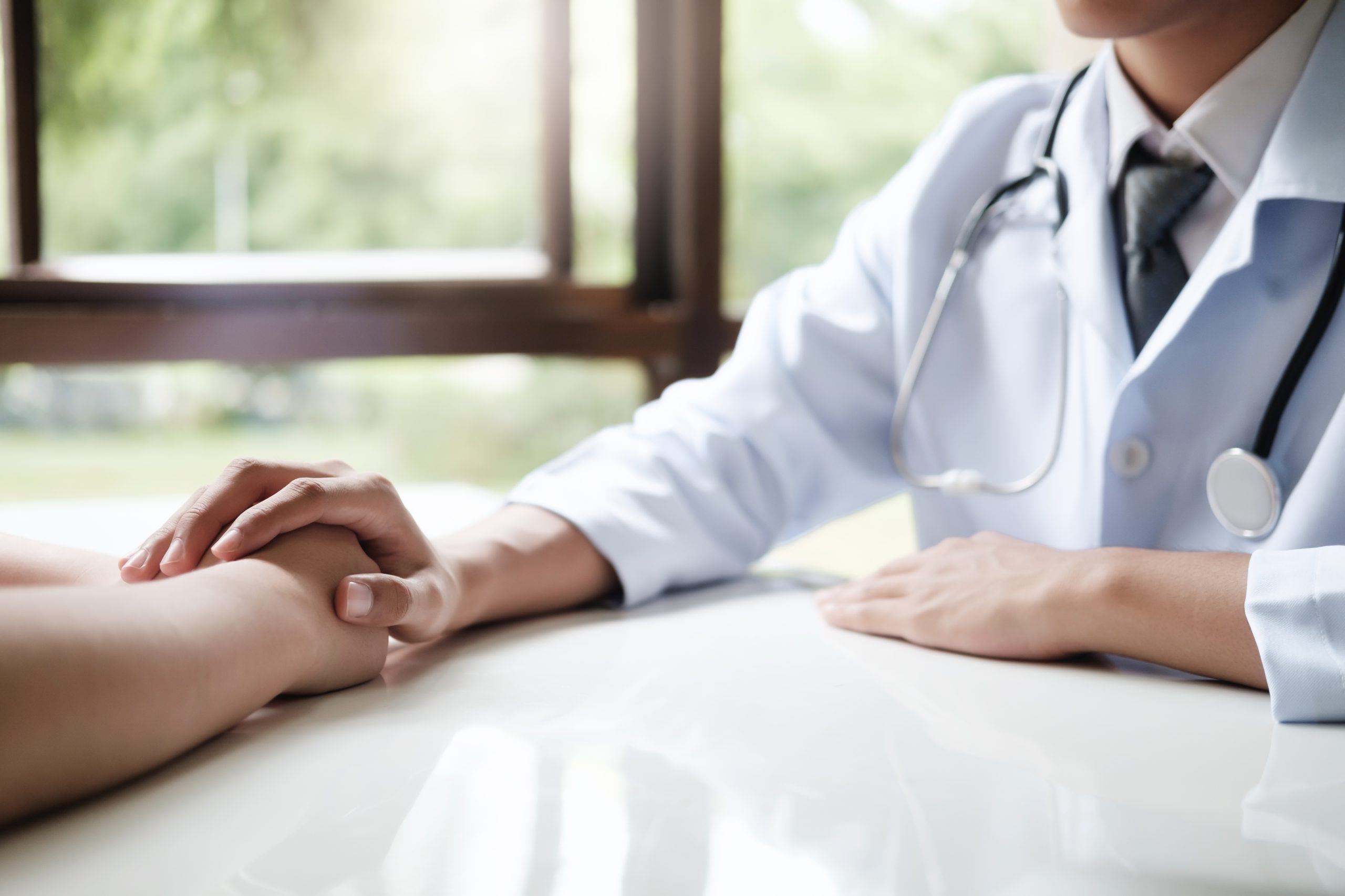 Doctor comforting patient at consulting room.