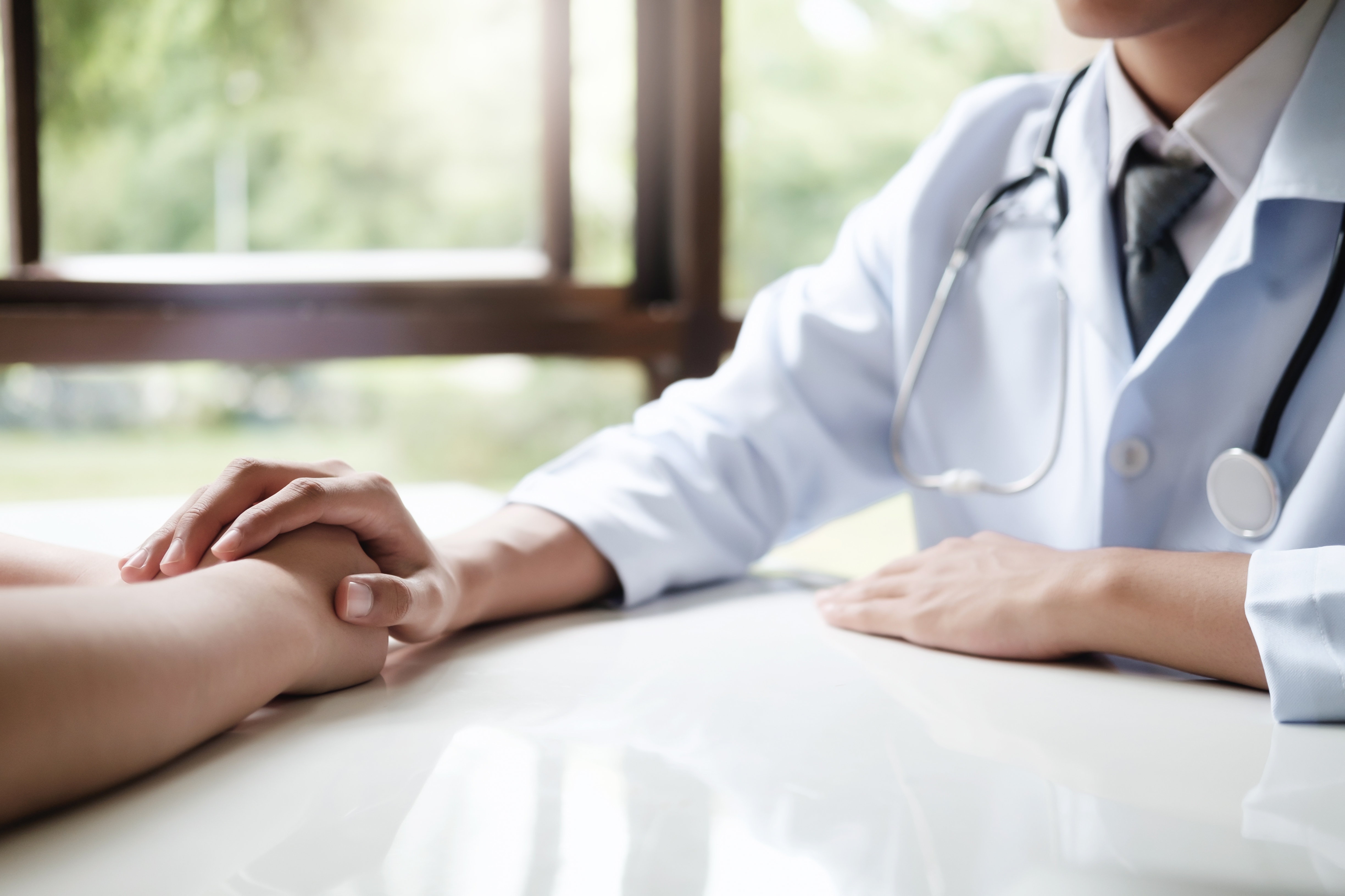 Doctor comforting patient at consulting room.